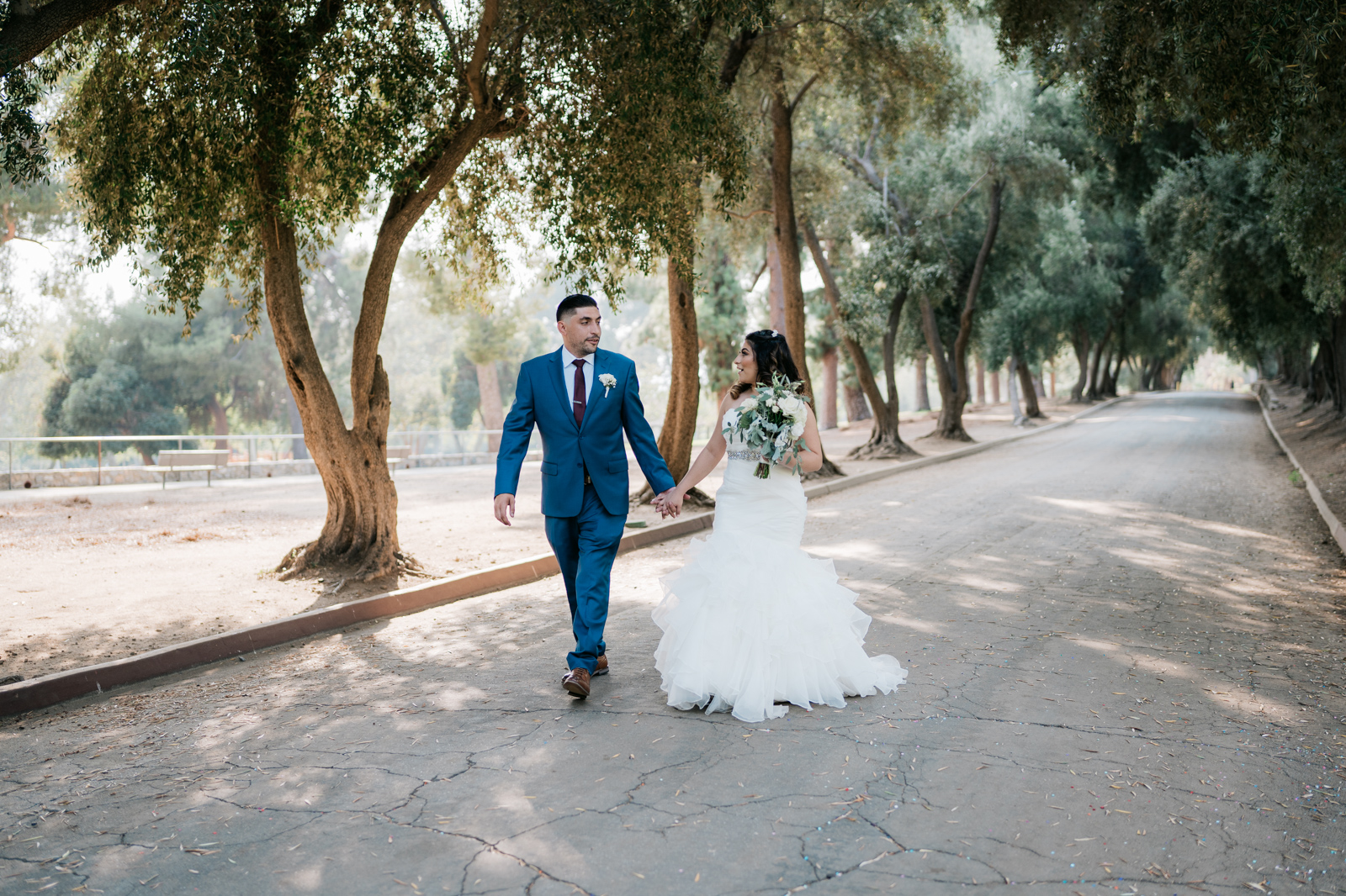 bride and groom walking down trail